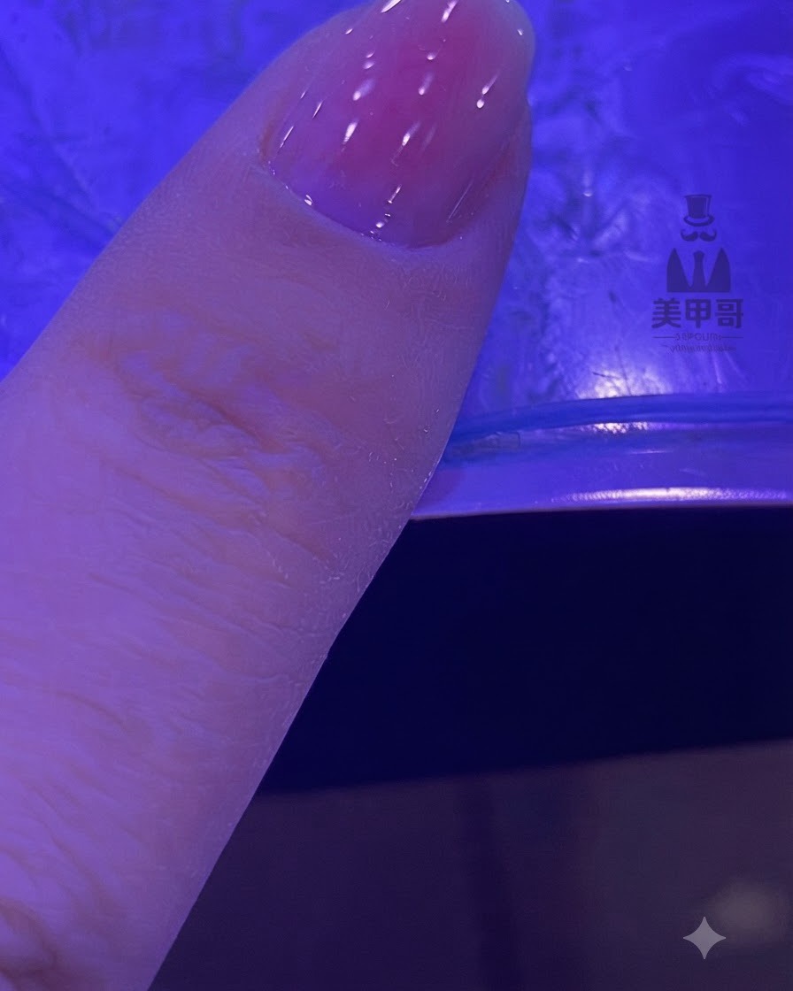 Ein Fingernagel mit einem verblendeten Rosa-Gradienten härtet unter einer UV- und LED-Lampe aus.