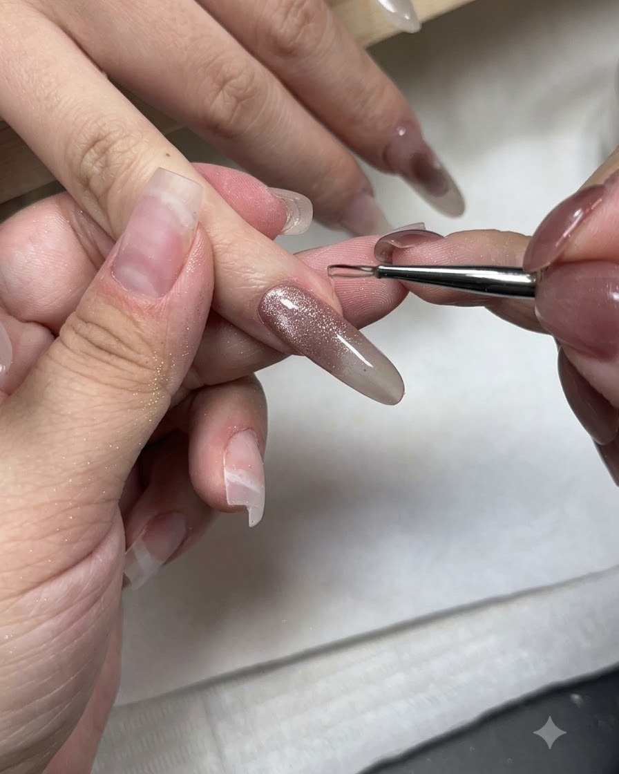 Ein feiner Nail-Art-Pinsel trägt Non-Wipe Styling-Gel auf die Spitze eines Cat-Eye-Gel-Nagels auf.
