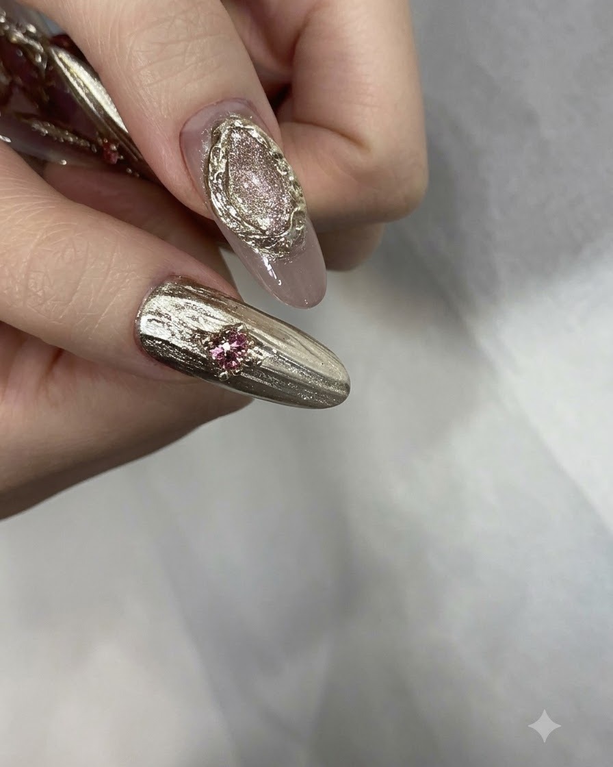 Fertig manikürte Finger, geschmückt mit rosa Strasssteinen, Goldperlen und strukturierten Chromdetails.