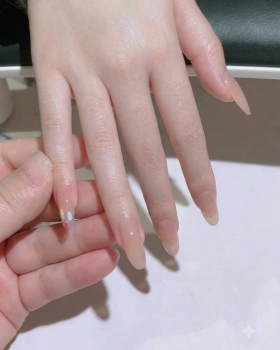 Eine fusselfreie Zellette reinigt die Nagelplatte des Mittelfingers.
