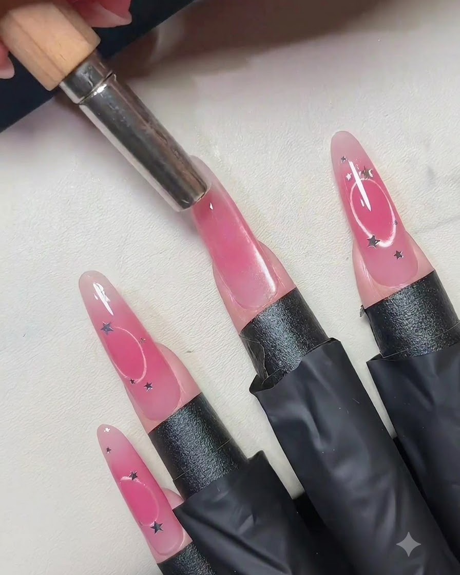 Ein zylindrischer Magnet wird vertikal über die Mitte eines rosafarbenen Cat-Eye-Gelnagels gehalten.