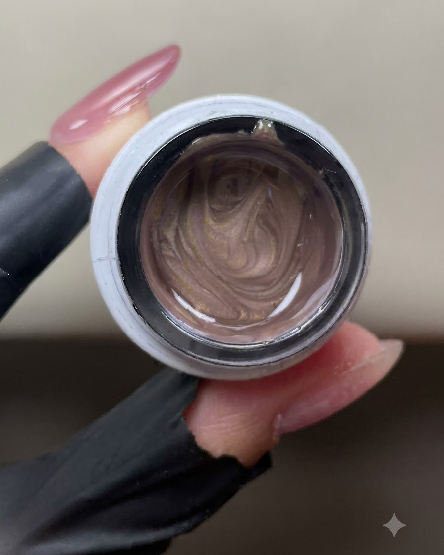 Ein geöffnetes Glas schimmerndes, roségoldenes Cat-Eye-Gel zeigt wirbelnde metallische Magnetpartikel im Inneren.