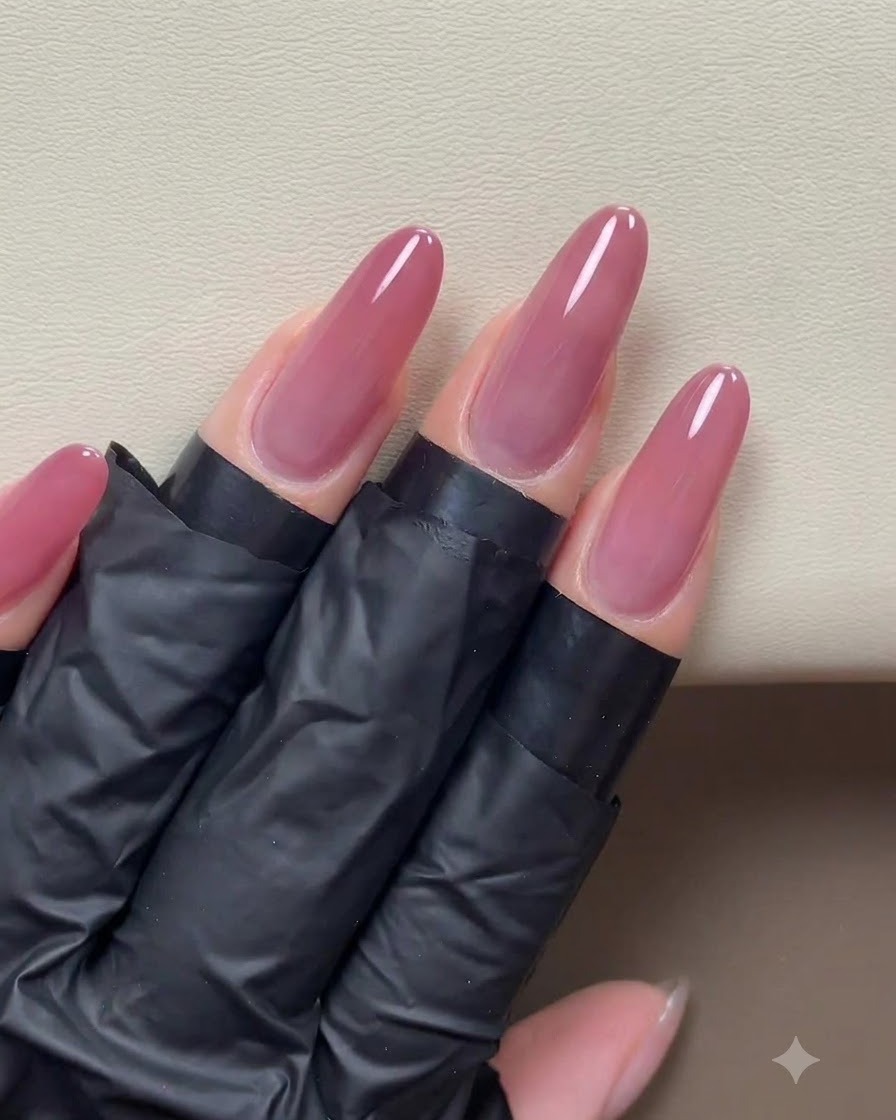 Eine vollständige Anwendung von roségoldenem Cat-Eye-Gel bedeckt die Oberfläche vorbereiteter langer Nägel gleichmäßig.