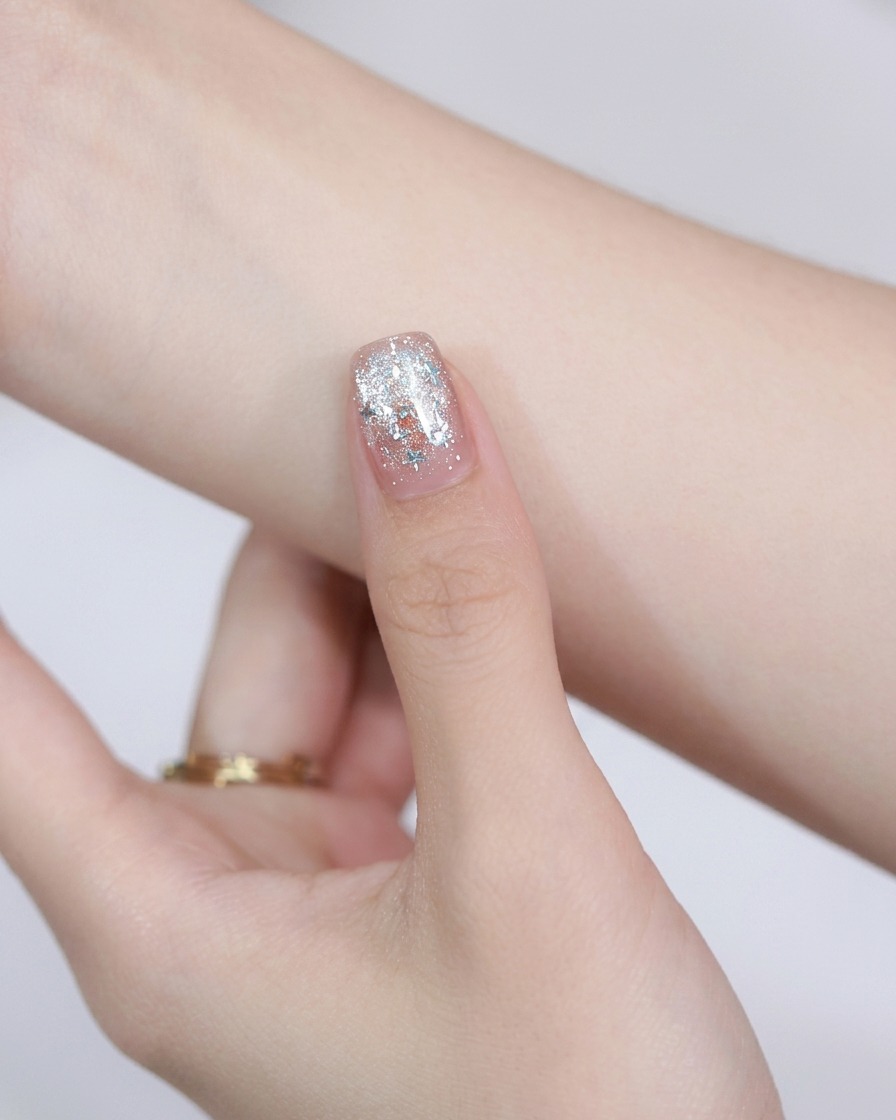 Ein runder Stahlmagnet wird über einen lackierten Nagel gehalten, um die magnetischen Cat-Eye-Partikel zu bewegen.