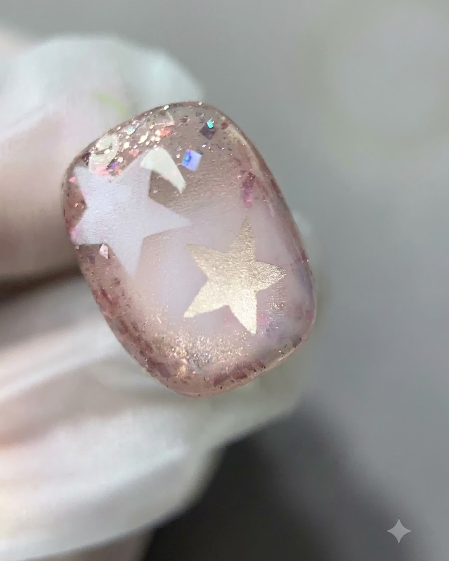 Ein Pinsel, der die innere Begrenzung des rosa Glittergels auf dem Nagel sanft verblendet.