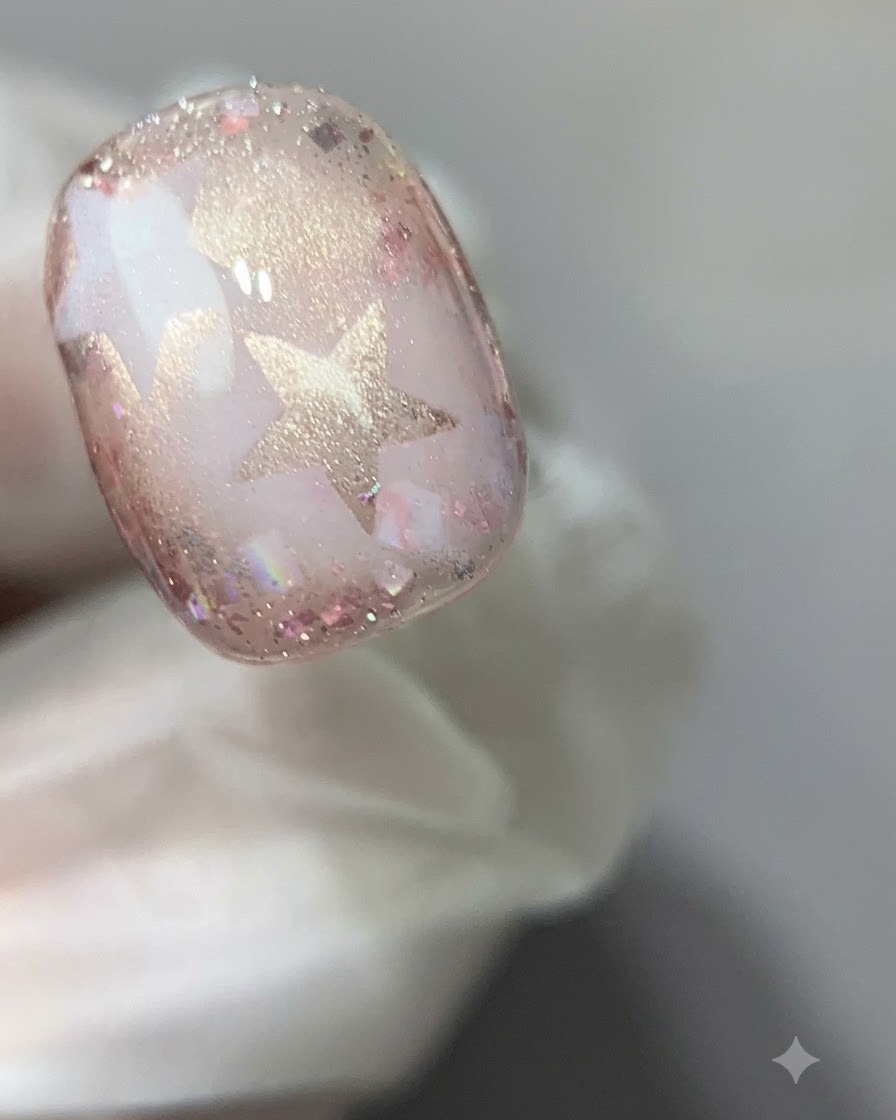 Eine Nahaufnahme eines ausgehärteten rosa Cat-Eye-Gel-Nagels unter einer Härtungslampe.