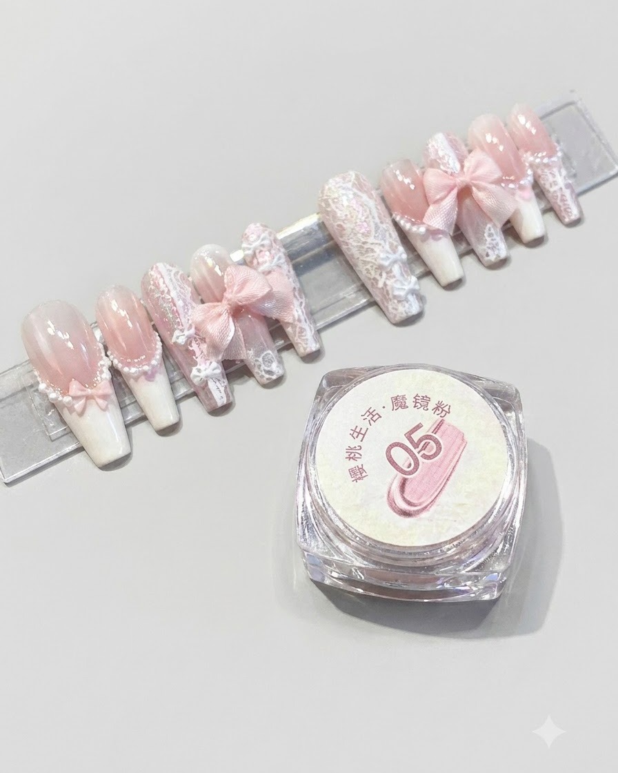 Ein Behälter mit Magic-Mirror-Puder Nummer 05 von Cherry Life, platziert neben einem Display-Ständer mit fertigen rosa Press-on Nägeln.