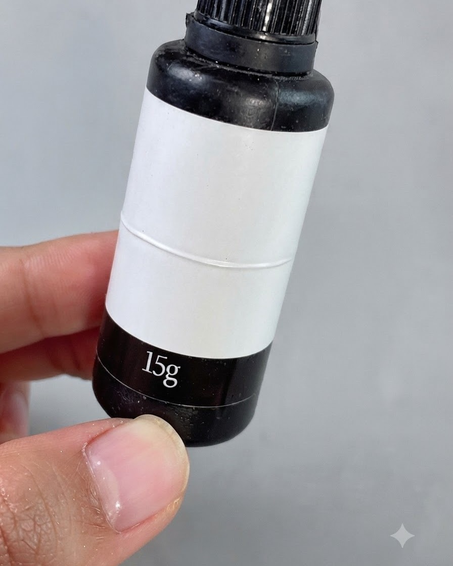 Ein feiner Detailpinsel trägt klares Fugenfüllgel um kleine quadratische Strasssteine auf einem manikürten Nagel auf.