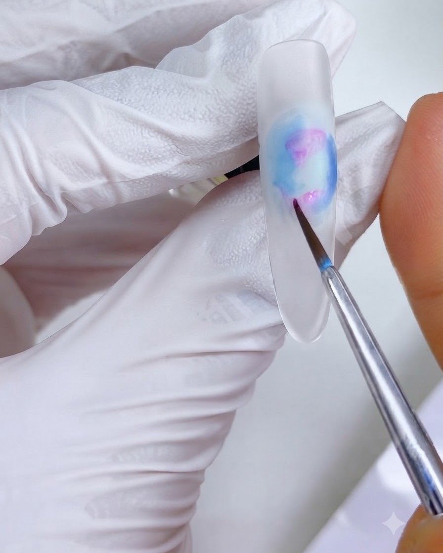 Ein feiner Detailpinsel trägt kleine rosa-magentafarbene Tintenpunkte auf die oberen und unteren linken Bereiche des Nageldesigns auf.