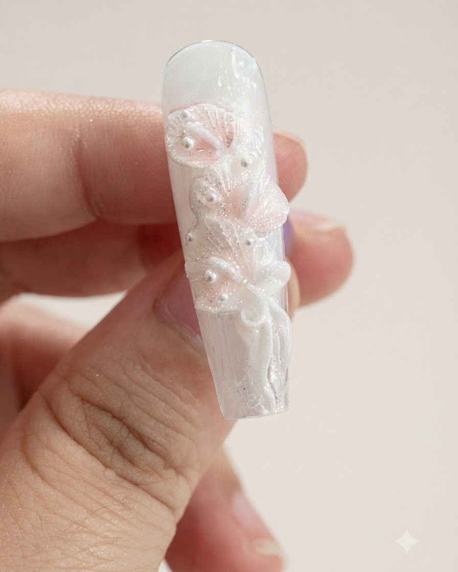 Eine Nahaufnahme eines Nagels mit mehreren skulpturierten weißen Calla-Lilien-Blütenblättern und einer Schleife.