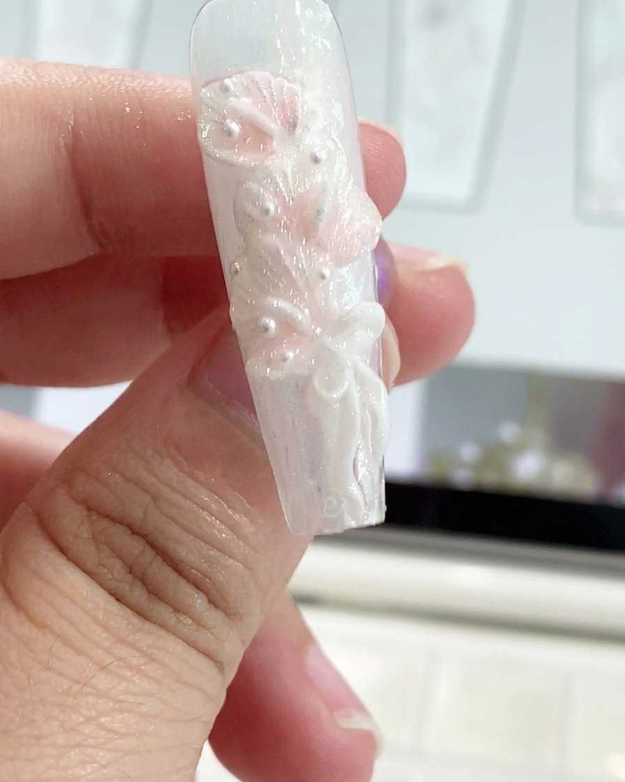 Ein Silikonwerkzeug formt ein Gel-Schleifenband auf einem verzierten Fingernagel.