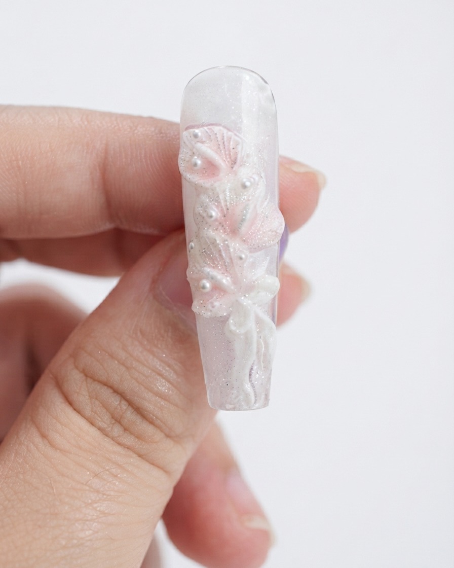Ein Make-up-Schwamm tupft hellrosa Gel auf skulpturierte weiße Calla-Lilien-Blütenblätter.