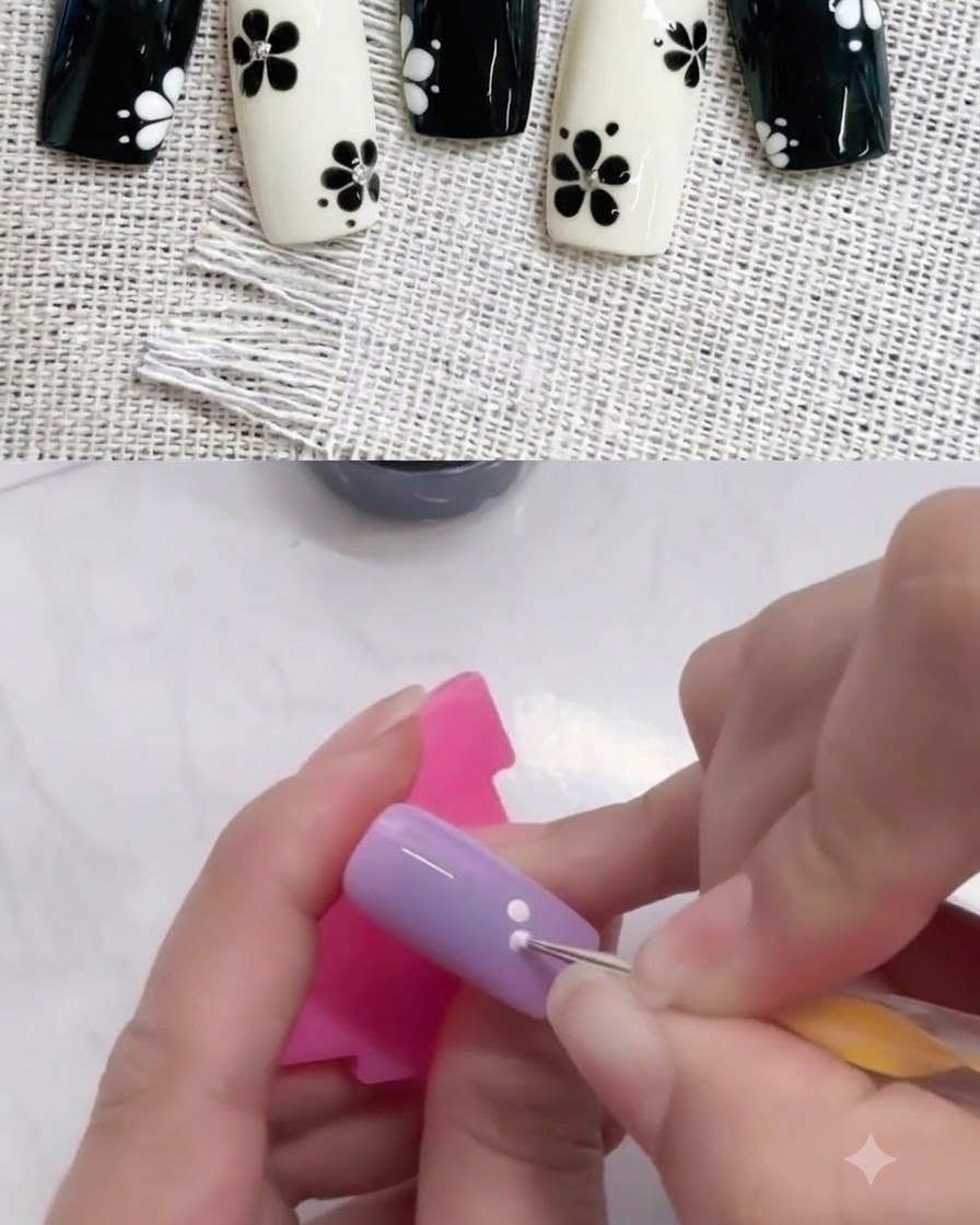 Ein Dotting Tool fügt einen zweiten weißen Punkt neben dem ersten auf einem lila Nagel hinzu.