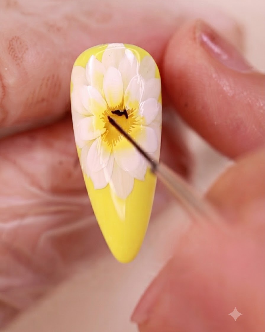 Ein feiner Liner-Pinsel zieht feine schwarze Linien in der Mitte des Blumen-Nageldesigns.