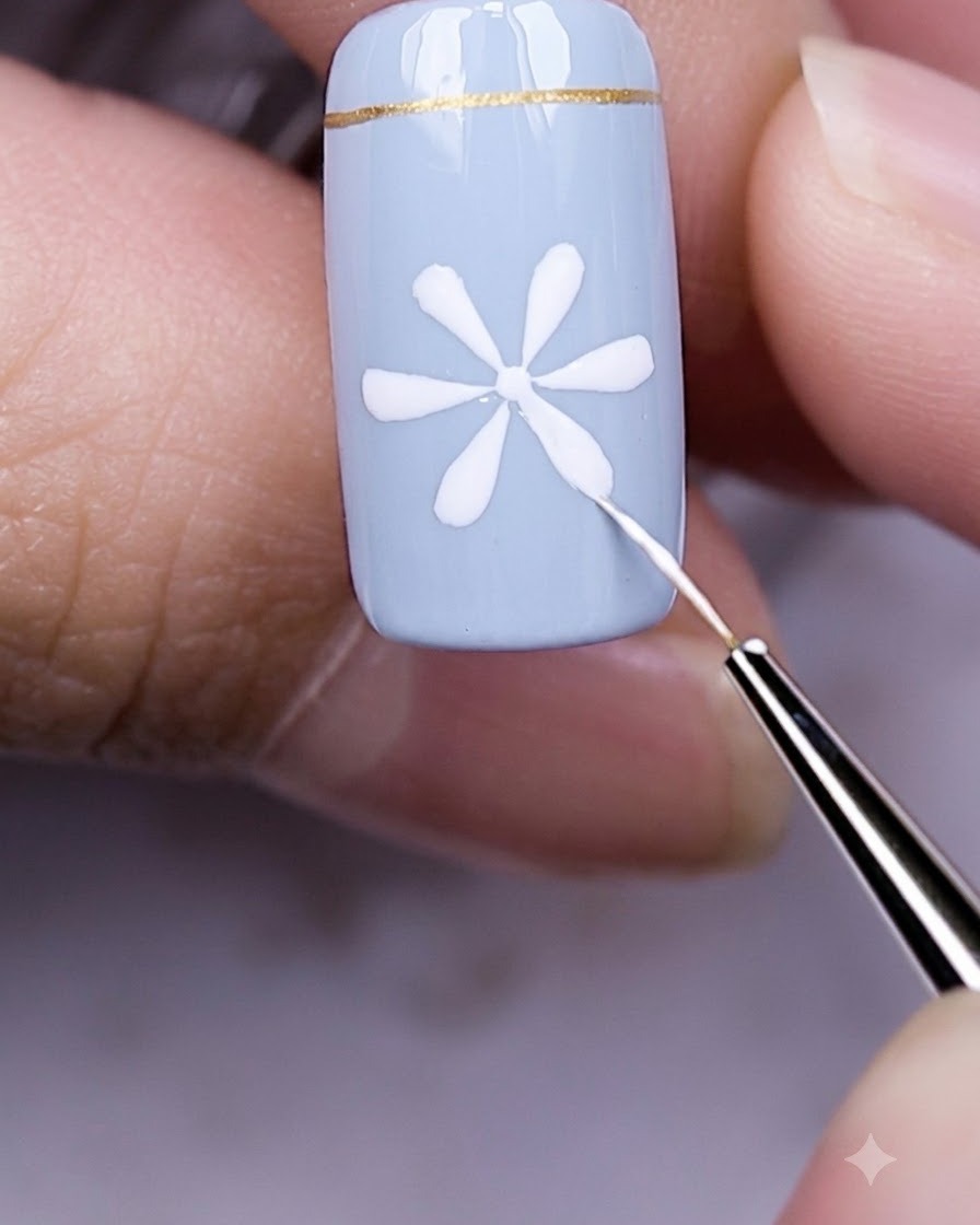 Finger mit einem blauen Nagel und weißem Gänseblümchen-Design ruhen unter einer leuchtenden UV-LED-Nagellampe.