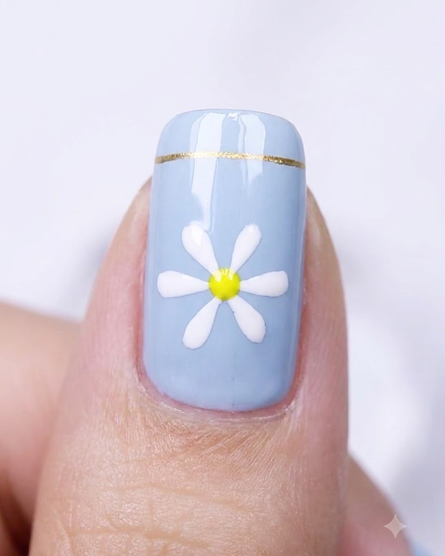 Eine Nahaufnahme eines blauen Nagels mit einem Gänseblümchen-Design in einem Nagelhärtungsgerät.