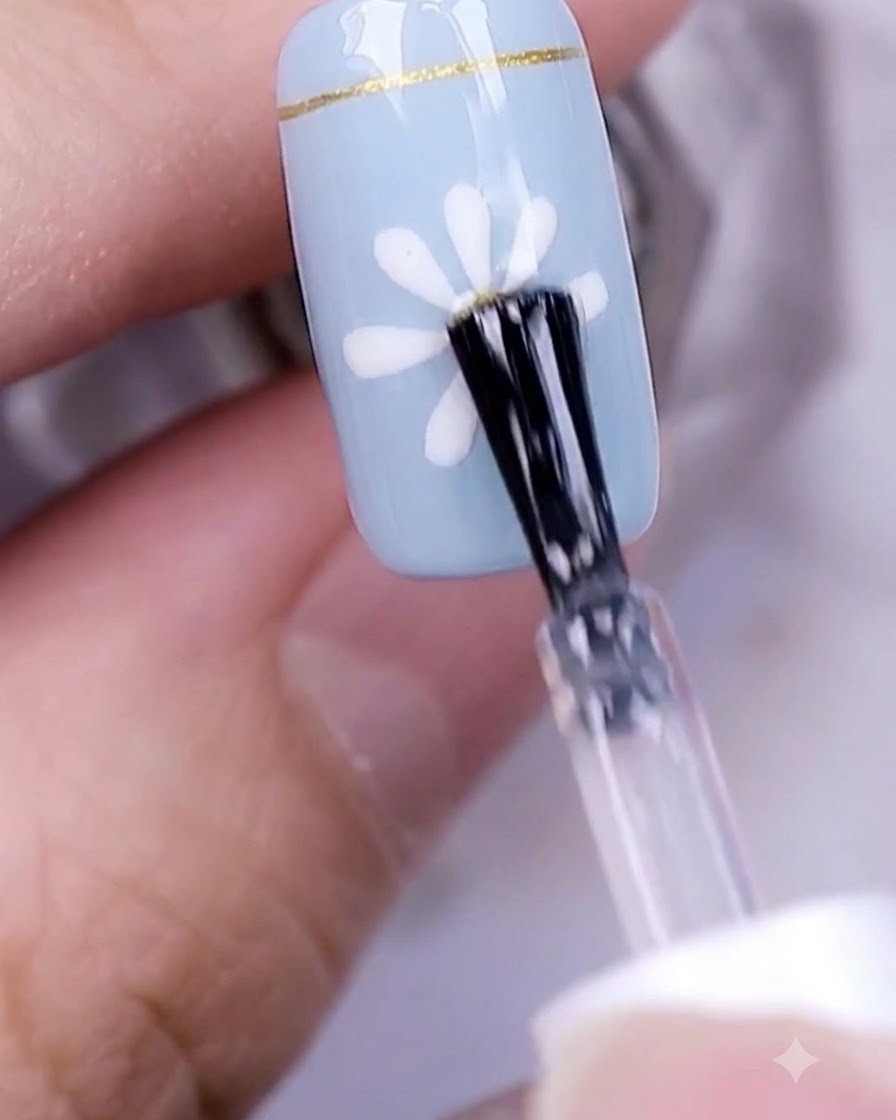 Eine Hand mit einem fertigen Gänseblümchen-Nageldesign härtet unter einer professionellen UV-Nagellampe aus.