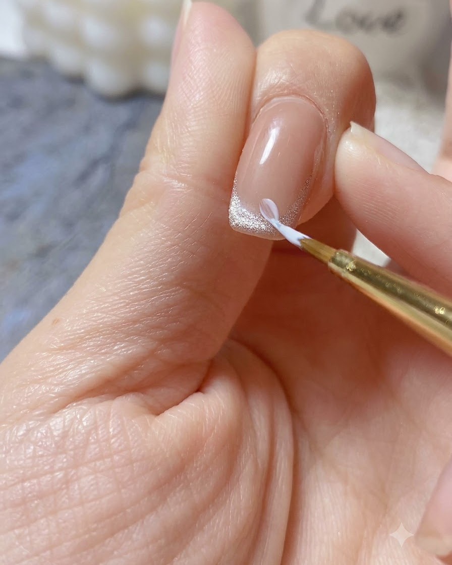 Ein feiner Pinsel trägt einen Tropfen dickes, weißes Reliefgel auf, um ein 3D-Gänseblümchen-Blütenblatt auf einer lackierten Nagelspitze zu formen.