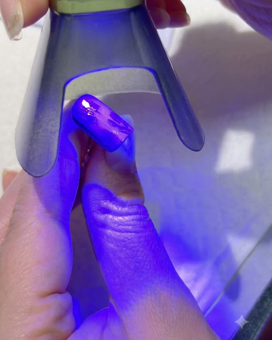 Eine lila UV-Lampe, die die hellgrünen Blattdetails auf einem lackierten Nagel aushärtet.