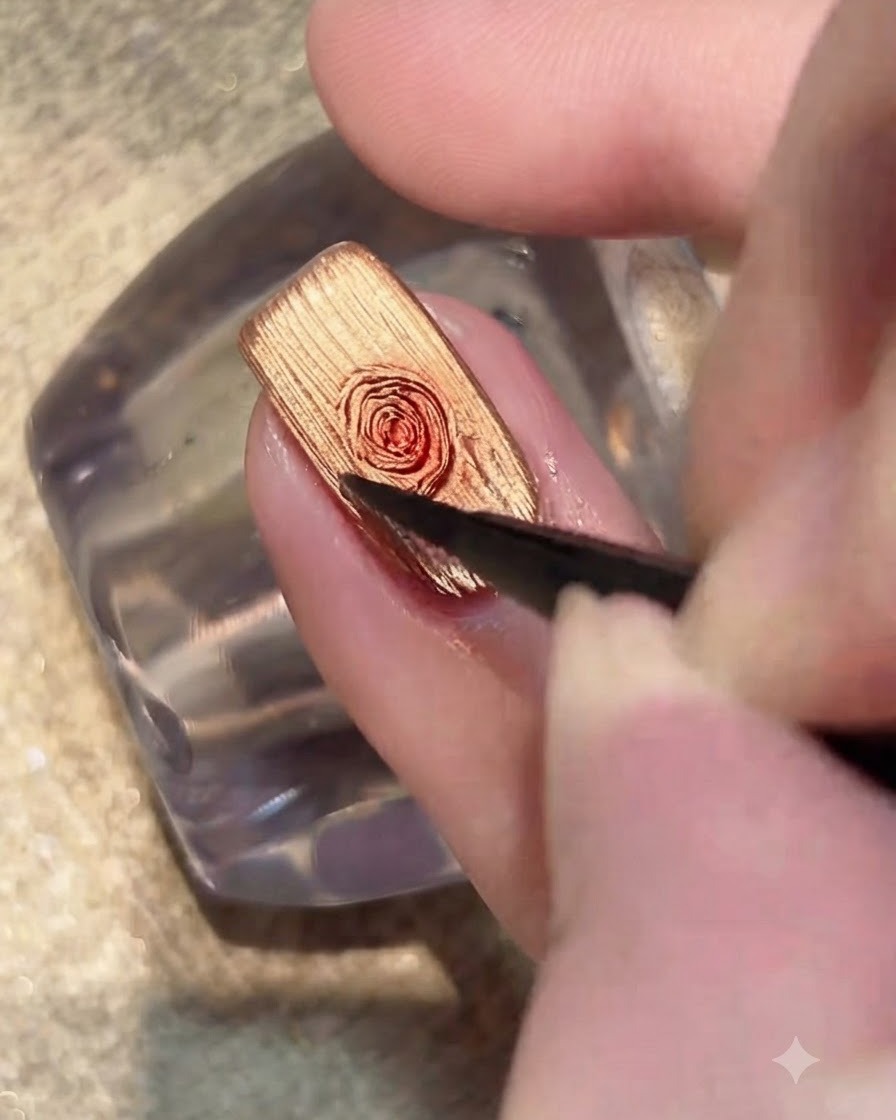 Ein Pinsel trägt eine transparente Schicht Blooming Gel über die goldene Cat-Eye-Nageloberfläche auf.