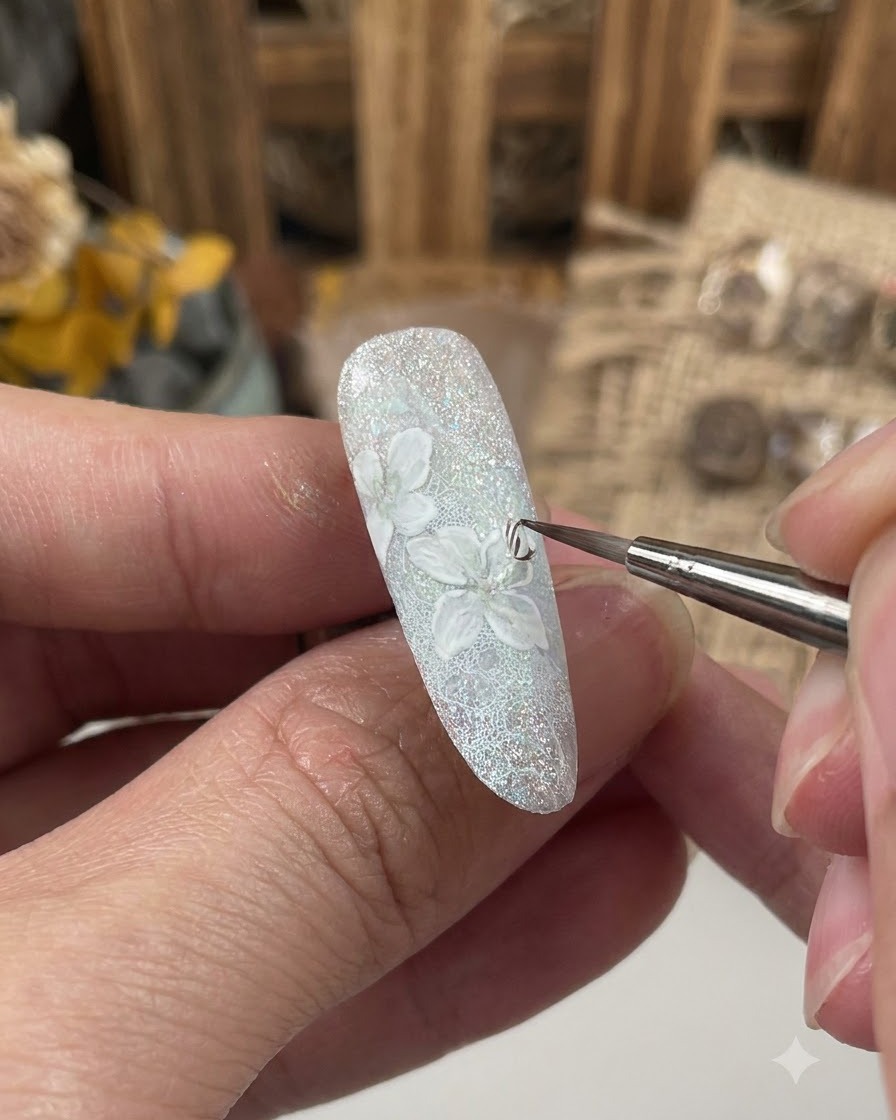 Ein feiner Pinsel trägt eine Versiegelungsgelschicht über dem detaillierten Blumendesign auf einem dekorierten Nagel auf.