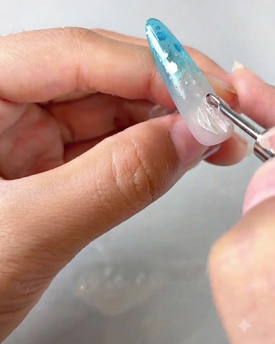 Ein Detailwerkzeug platziert und hebt die Ränder eines transparenten Blütenblatt-Gels auf einem verzierten Nagel an.