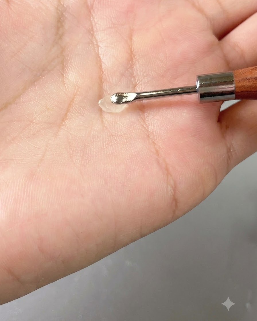 Eine kleine Portion transparentes Gel ruht auf einem Handwerkzeug gegen die Handfläche.