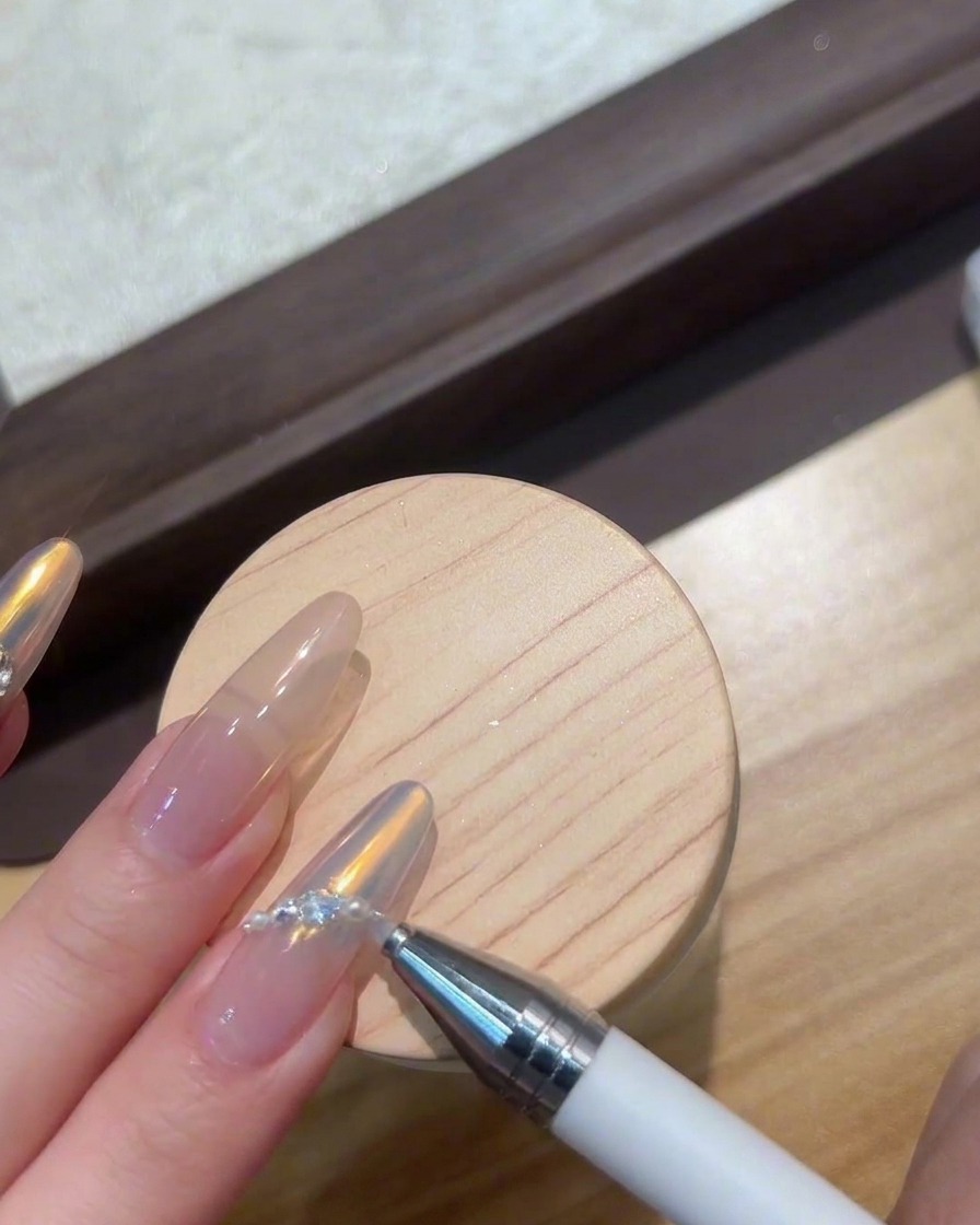 Finger werden unter einer kompakten UV-/LED-Lampe platziert, um Nail-Art-Edelsteine auszuhärten.