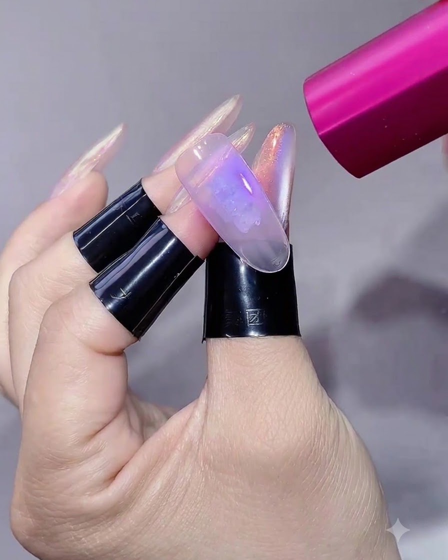 Eine pinke UV/LED-Handlampe strahlt Licht auf eine manikürte Nagelverlängerung.