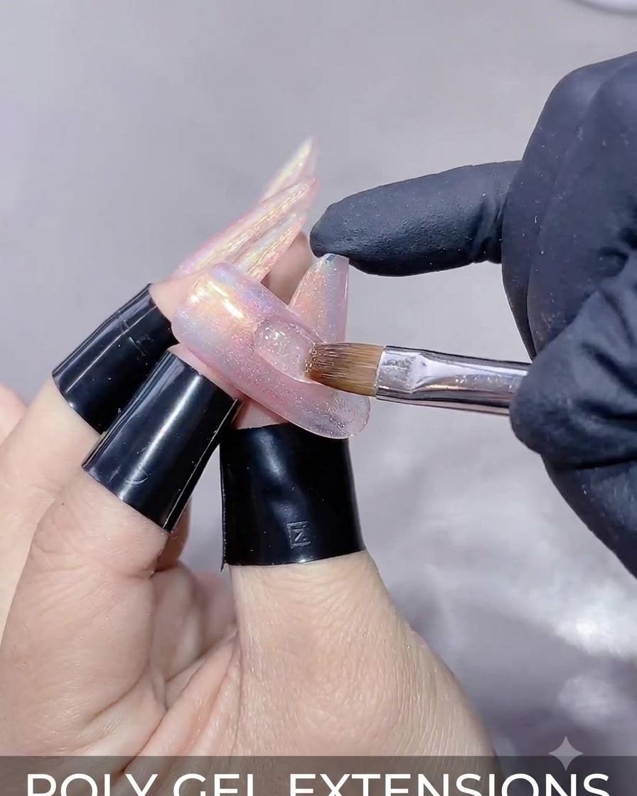 Nahaufnahme einer Hand, die einen Magnetstab über eine verlängerte Nagelverlängerung hält, um die Cat-Eye-Gel-Reflexion zu formen.