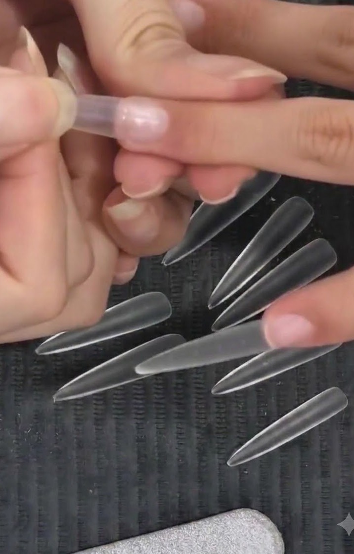 Eine Nageldesignerin drückt einen transparenten Mandeltip mit einer Hochpositionierungstechnik auf einen Naturnagel.