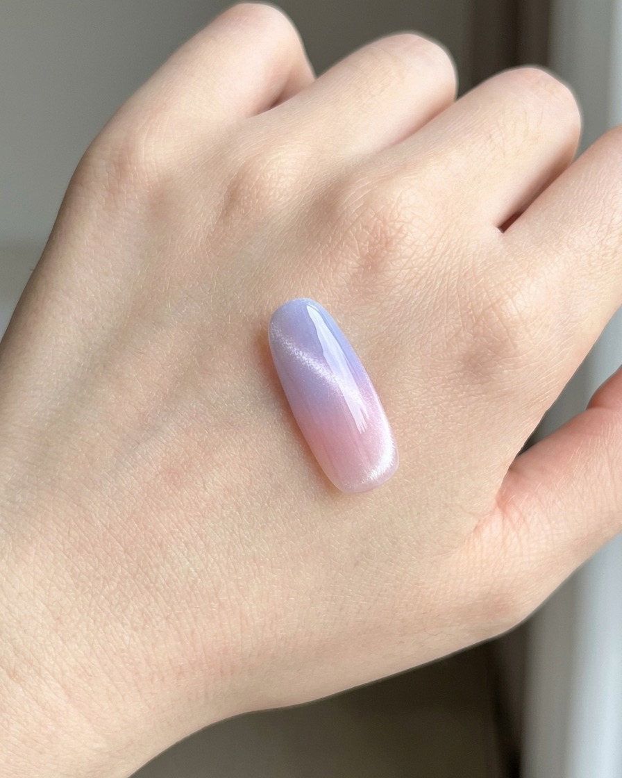Eine Nagelspitze unter einer UV/LED-Lampe beim Aushärten der Basislackschicht.