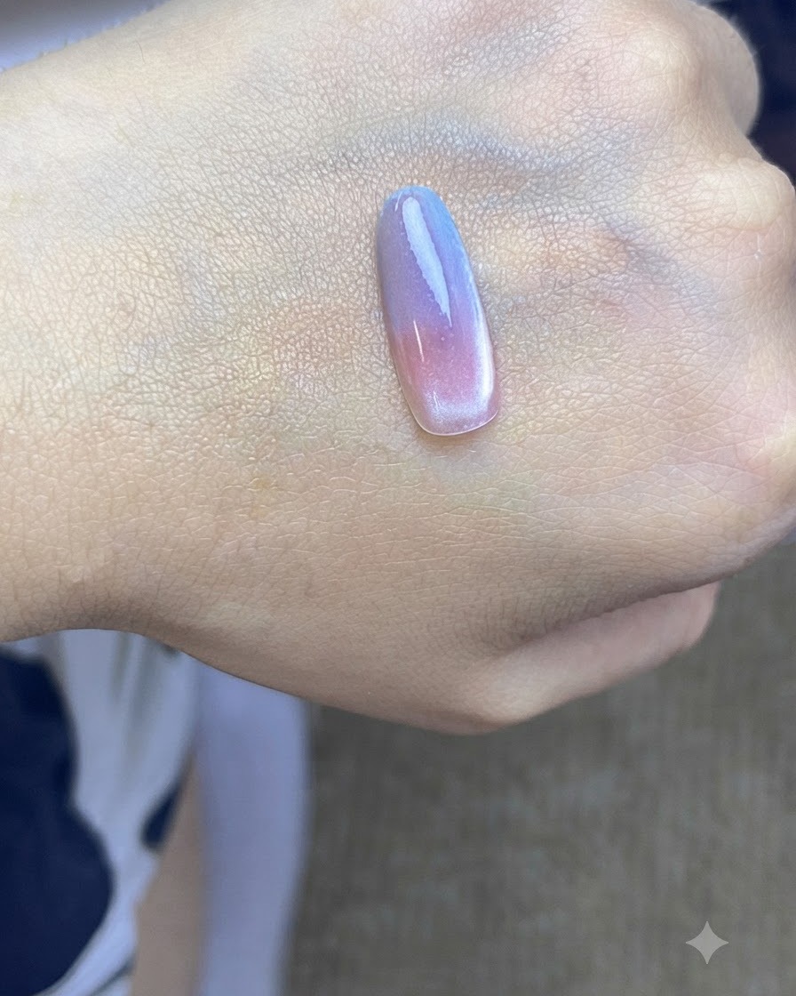 Eine Nagelspitze unter einer UV-Aushärtungslampe nach dem Auftragen der zweiten blauen Farbverlaufsschicht.