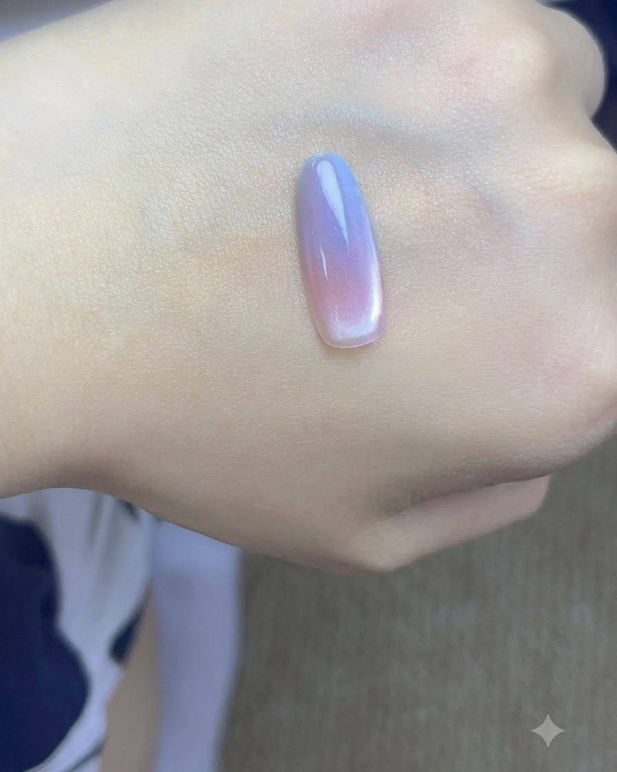 Ein kleiner Magnet wird nah an die Seite einer lackierten Nagelspitze gehalten, um Cat-Eye-Partikel zu konzentrieren.