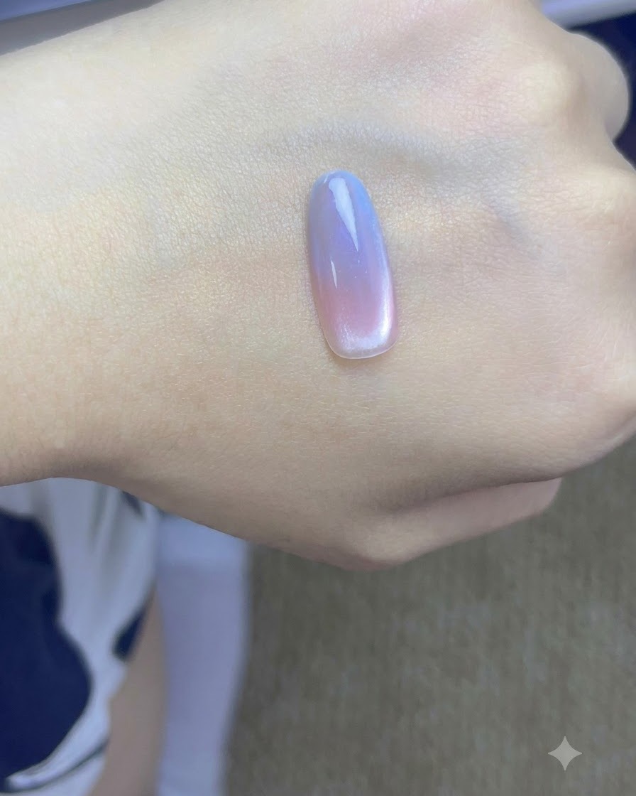 Eine Hand mit fertigen Farbverlaufs-Cat-Eye-Nägeln beim Aushärten unter einer professionellen UV-Nagellampe.