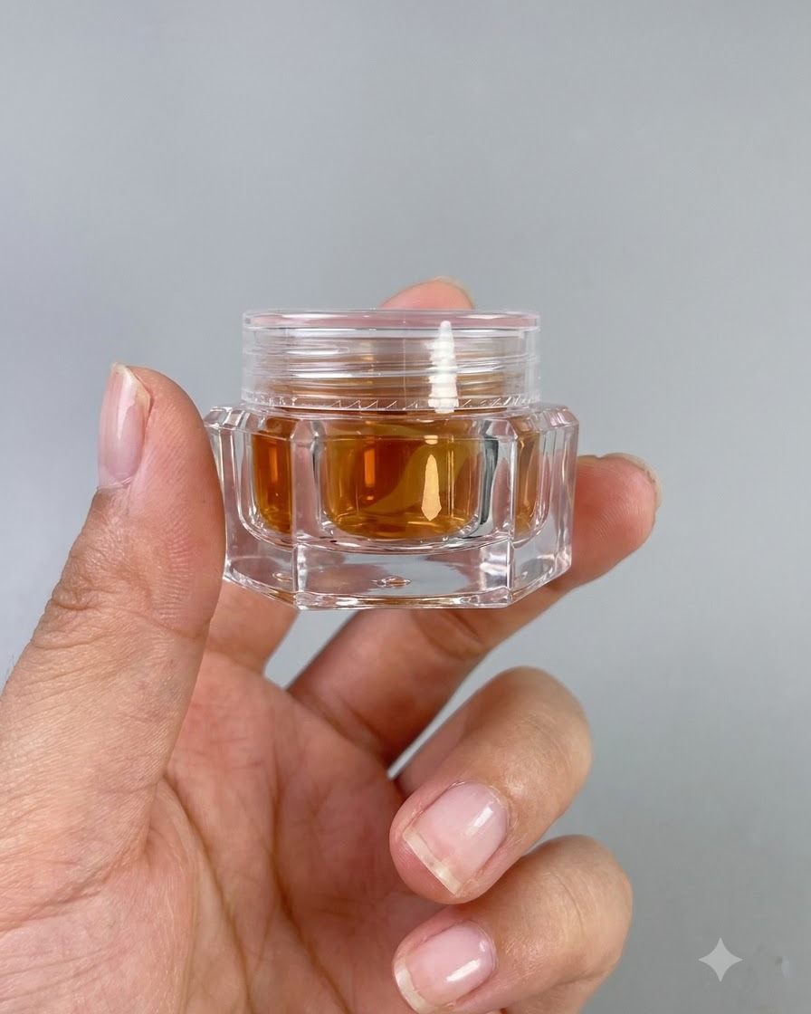 Ein kleines Glas bernsteinfarbenes Hochtransparenz-Glasgel Nr. 9 wird in einer Hand gehalten.