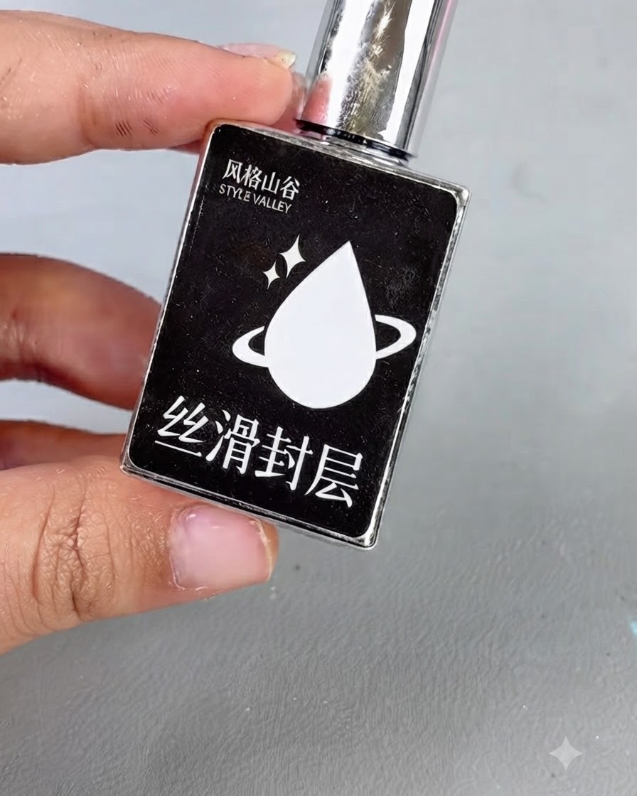 Eine schwarze Flasche mit silberner Kappe und einem weißen Tropfensymbol mit Text, die glatten Topcoat darstellt.
