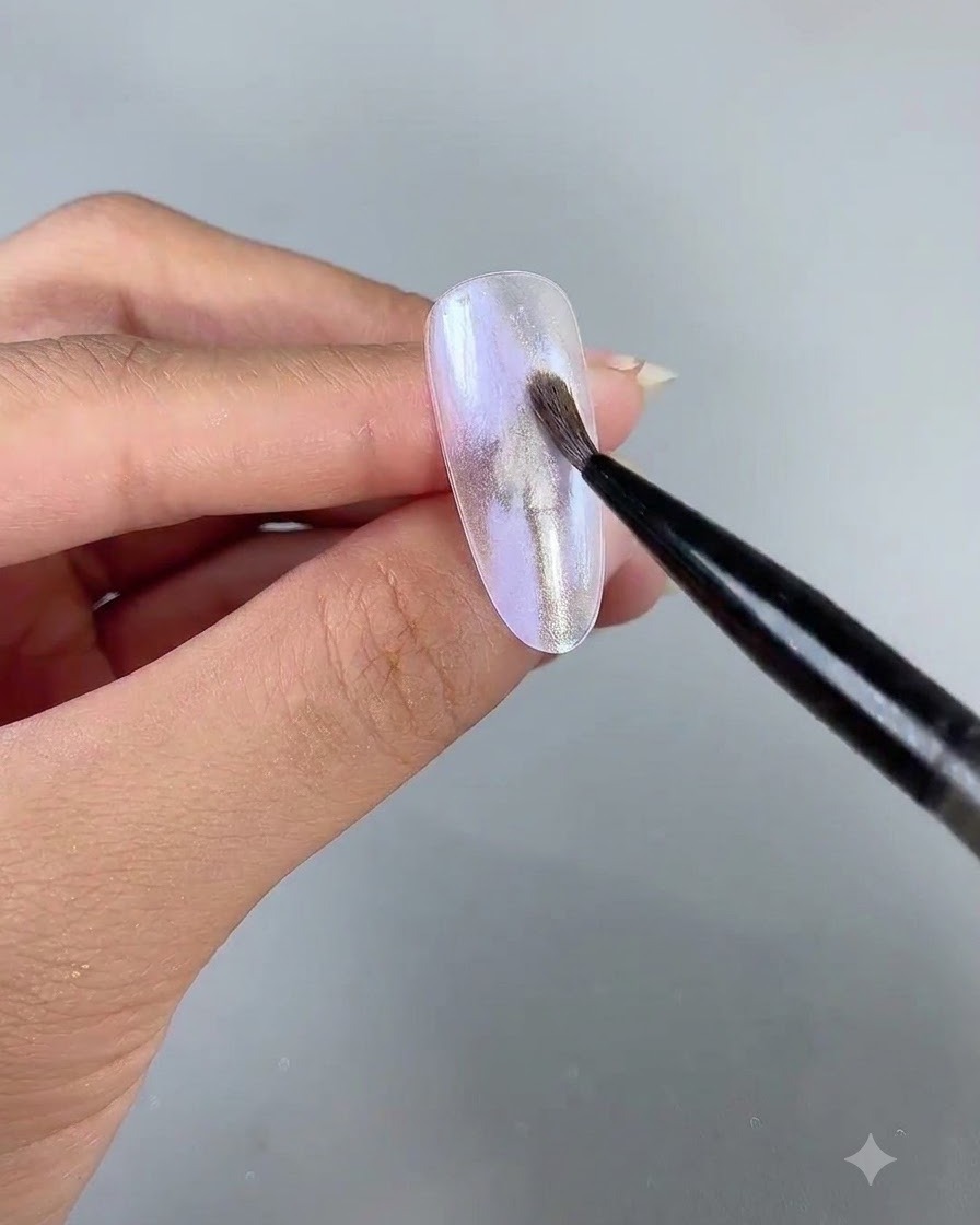 Ein feiner Nail-Art-Linienpinsel trägt zartes Perlglanz-Gel Nummer 3 über die Nageloberfläche auf.