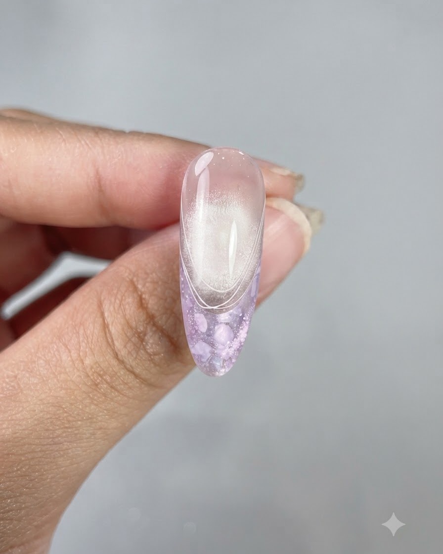 Ein fertiger langer, mandelförmiger Nagel mit glänzendem Top Coat, Cat-Eye-Finish und zarten weißen French-Linien.