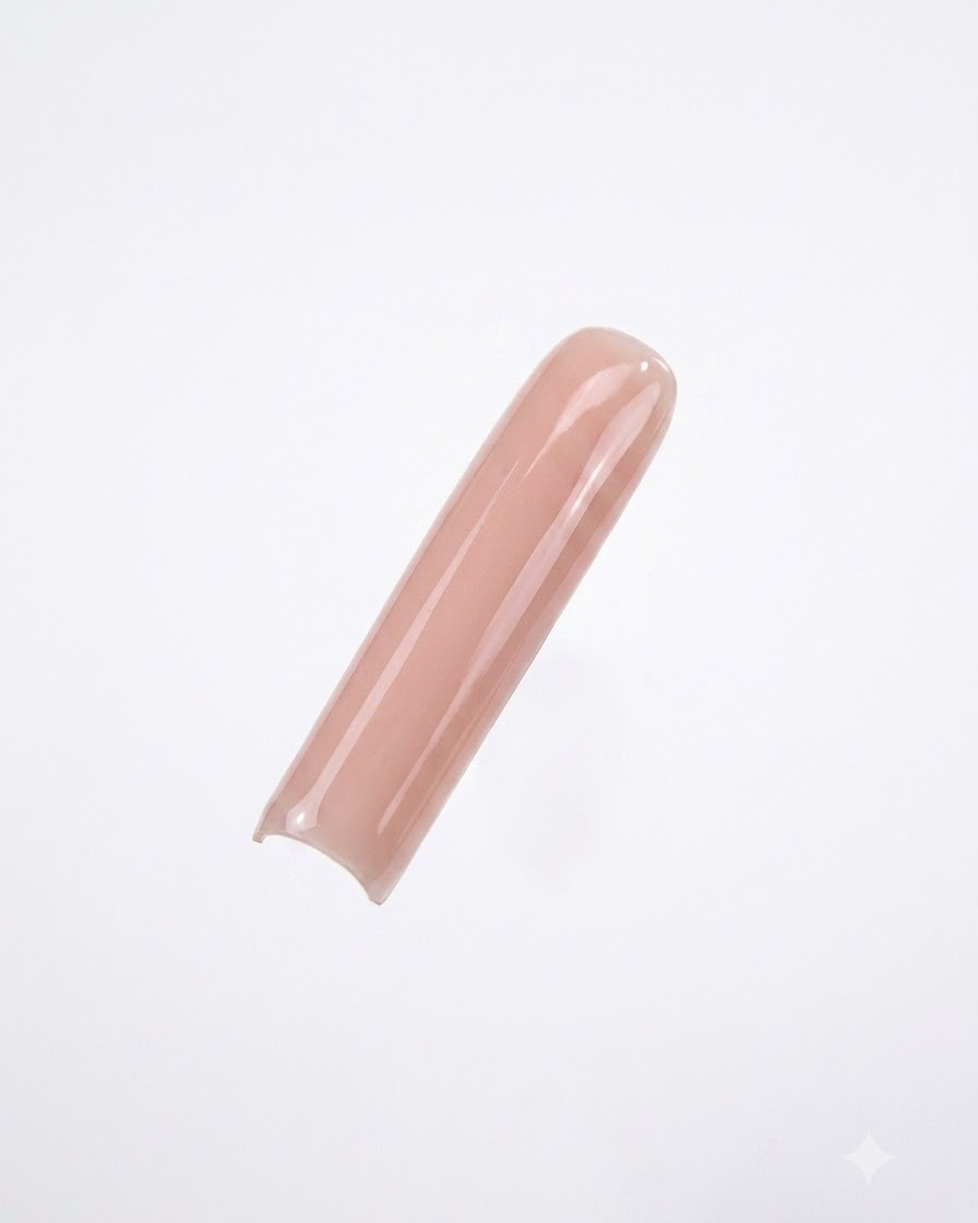 Ein langer, eckiger Nageltip, der mit einem gleichmäßigen, deckenden Nude-Gelack vor einem klaren weißen Hintergrund lackiert ist.