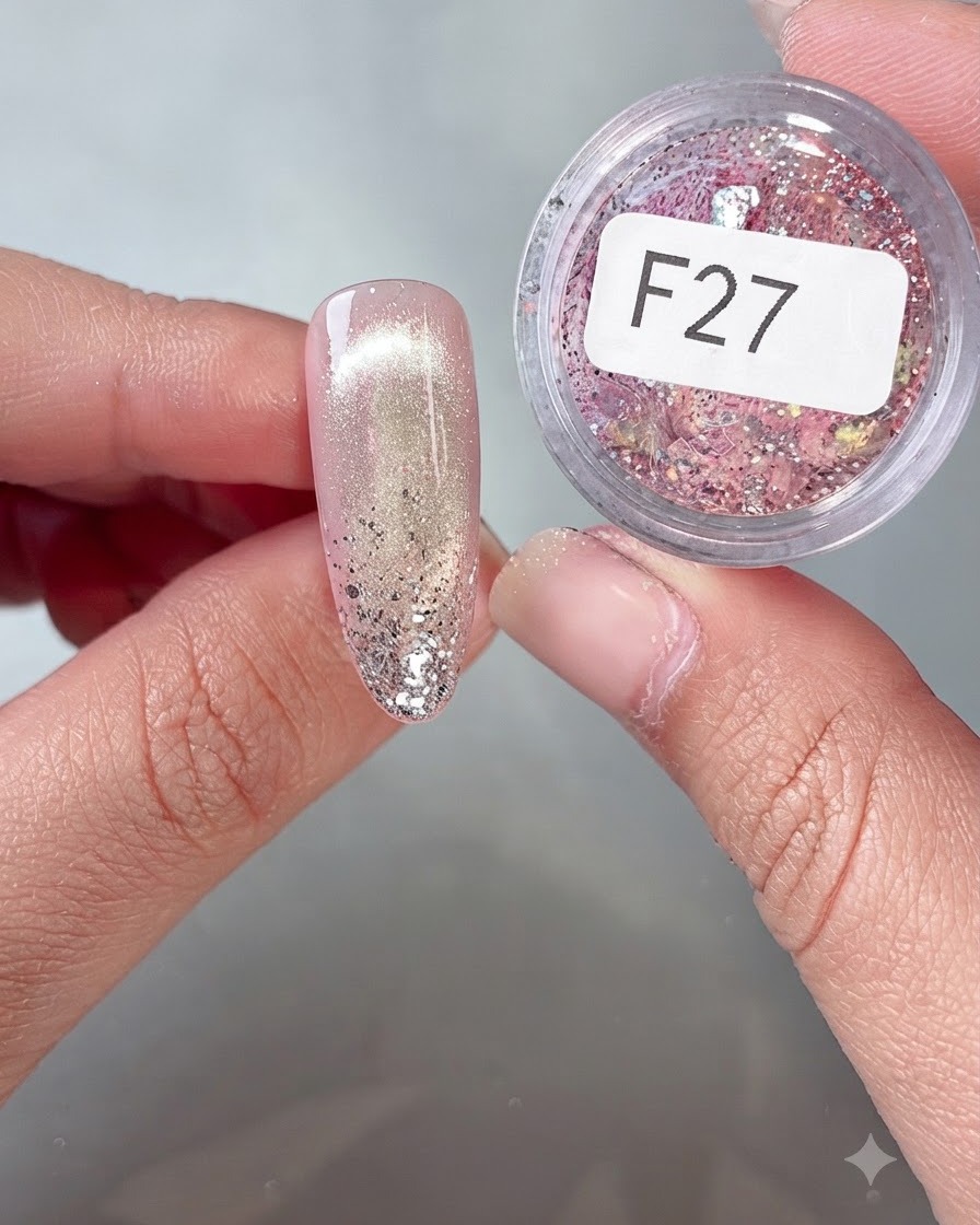 Eine Nahaufnahme eines Nagels, der mit einem Feinwerkzeug mit bunten Flocken-Pailletten aus dem Tiegel F27 dekoriert wird.
