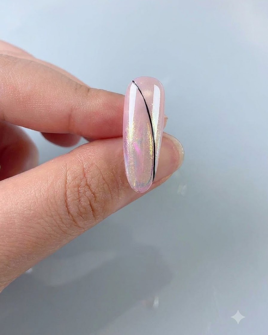 Ein feiner Liner-Pinsel zeichnet eine zarte, schwarze geschwungene Linie auf einen rosafarbenen Aurora-Nagel.
