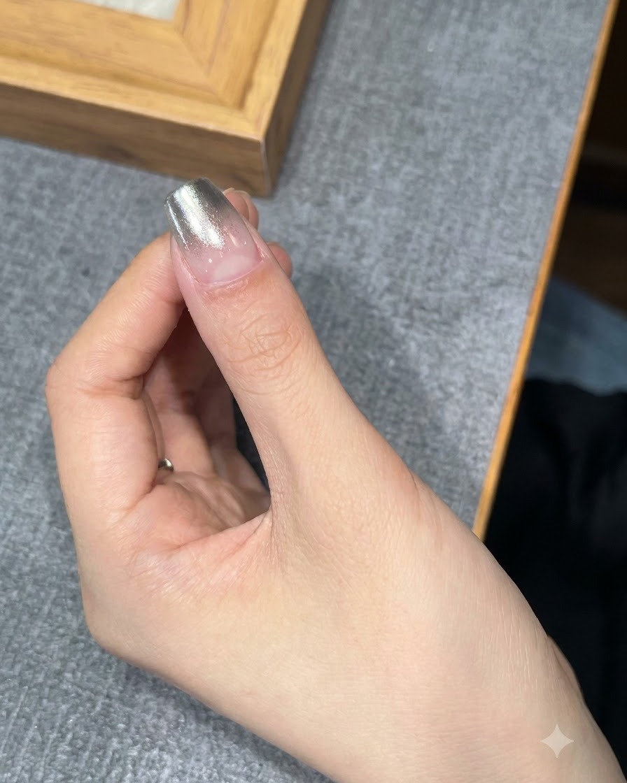 Ein Fingernagel wird zum Aushärten unter eine UV- oder LED-Lampe gelegt.