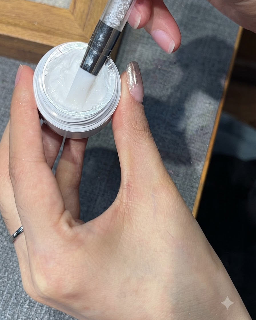 Ein Werkzeug entnimmt eine kleine Menge weißes Stamping-Gel aus seinem Tiegel.