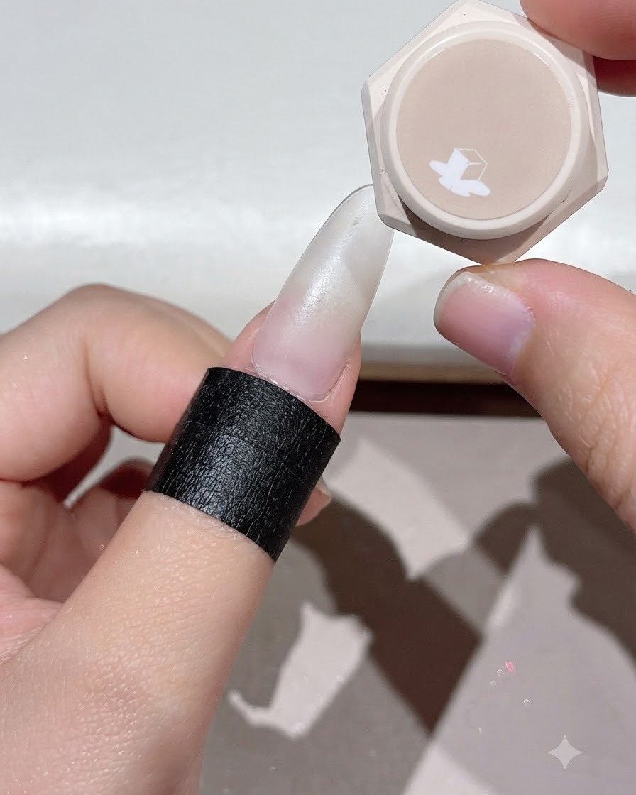 Ein Finger wird unter eine UV- oder LED-Nagellampe gelegt, um die aufgetragene Gelschicht auszuhärten.