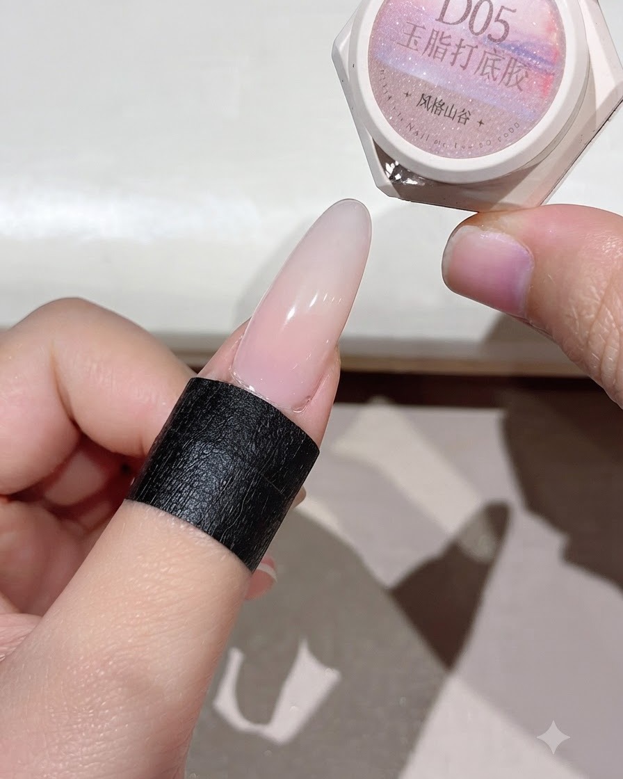 Ein ausgehärteter Nagel zeigt eine gleichmäßige pinkfarbene Basisschicht unter Beleuchtung.