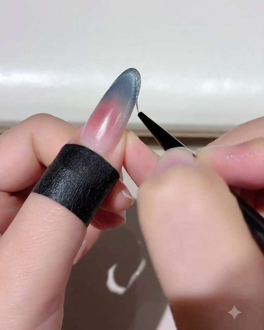 Ein feiner Liner-Pinsel trägt Platin-Gold-Gel entlang der Kante einer Nagelspitze auf.