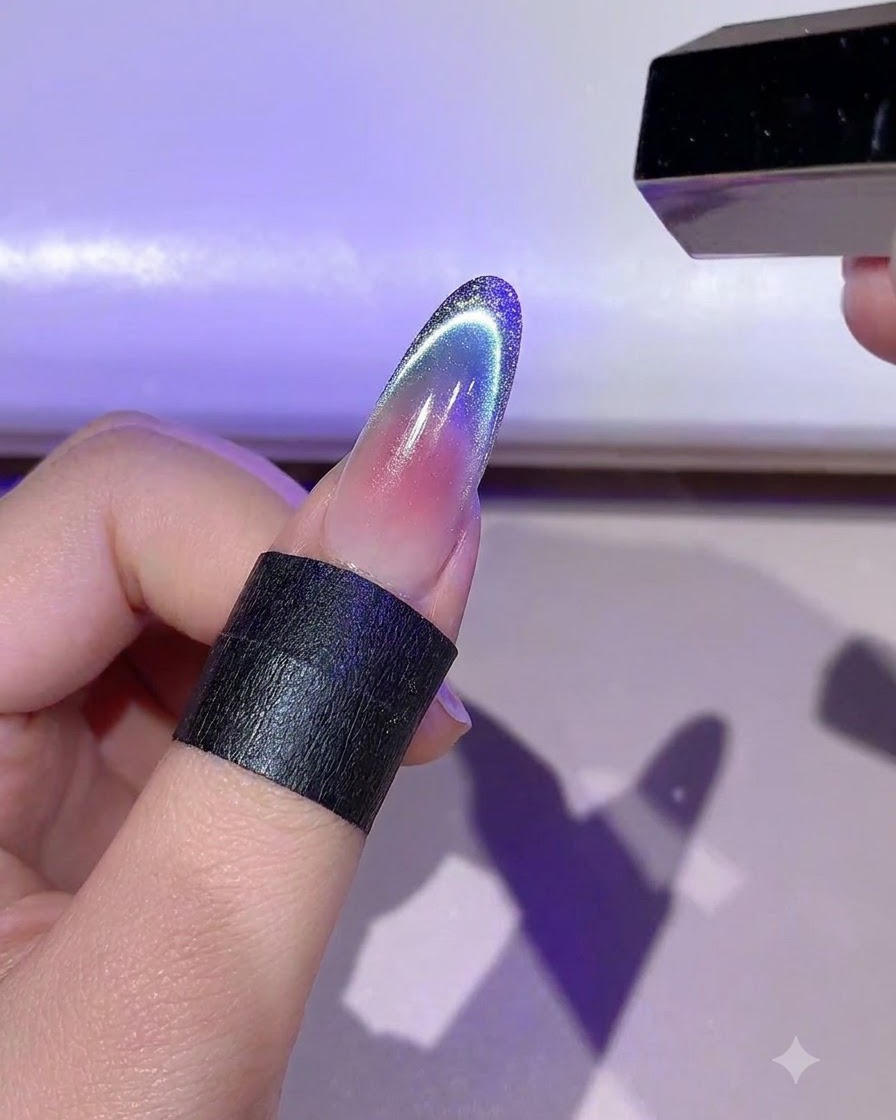 Eine Hand hält eine Mini-LED-Lampe, die die detaillierte Gold-Gel-Umrandung auf einem Fingernagel aushärtet.