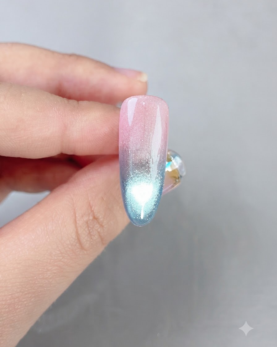 Ein fertiger rosa-blauer Gradient-Nagel zeigt eine helle Cat-Eye-Spiegelungslinie in der Mitte.