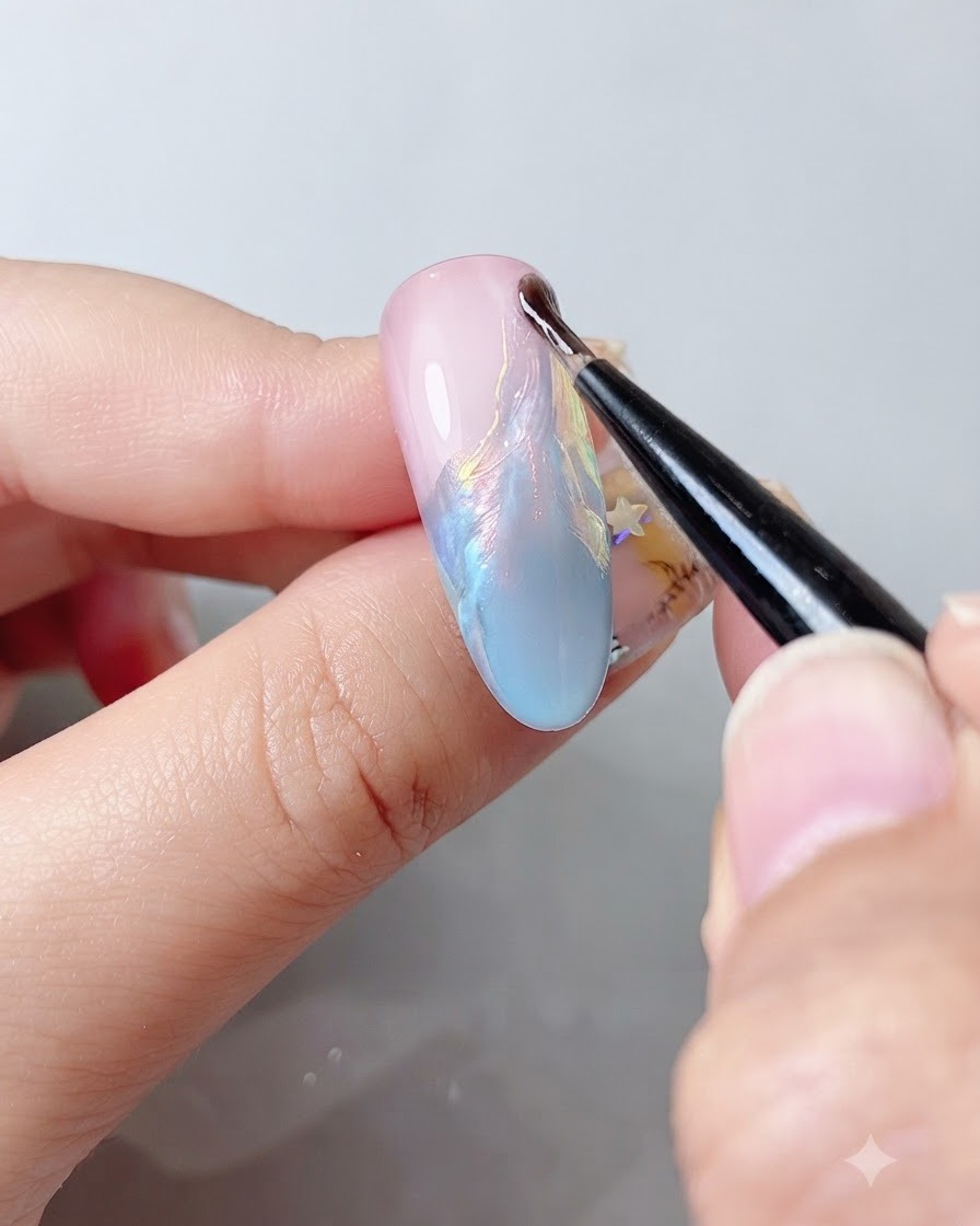 Ein feiner Nagelpinsel trägt einen klaren Top Coat über eine schimmernde, mehrfarbige Nageloberfläche auf.